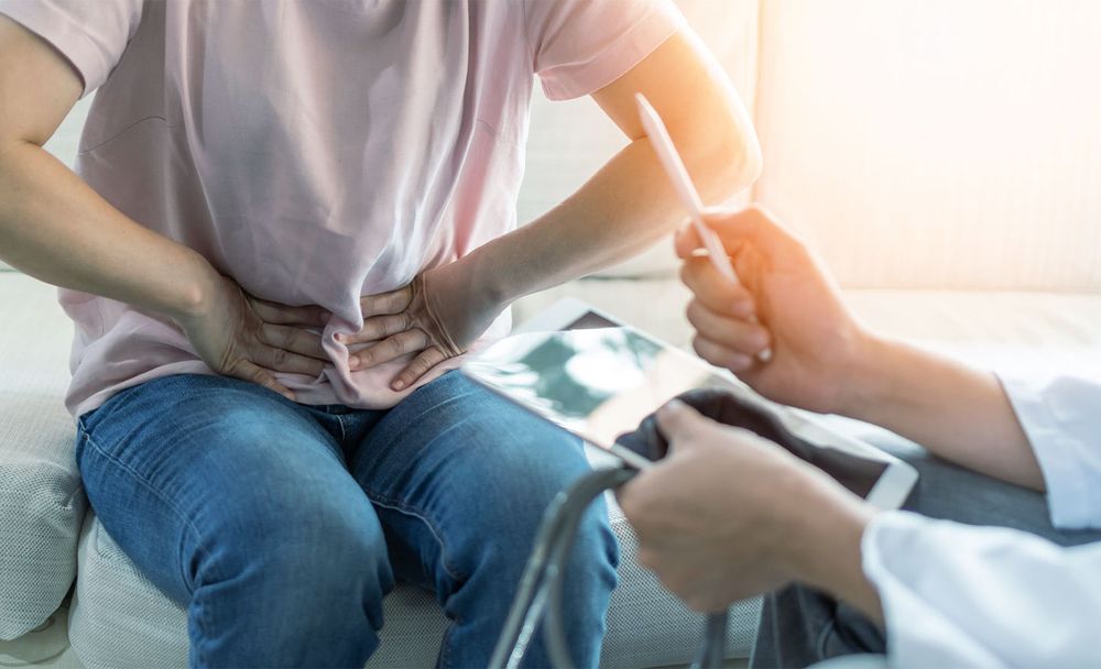 Person Holding Their Stomach at Doctor Visit